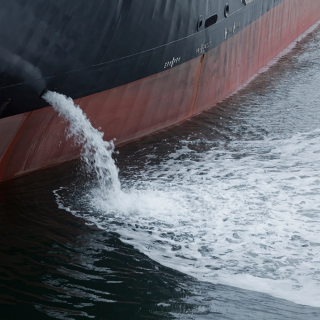 Aus einem Schiff wird Wasser abgelassen.